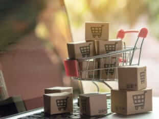 Shopping online concept - Parcel or Paper cartons with a shopping cart logo in a trolley on a laptop keyboard. Shopping service on The online web. offers home delivery.